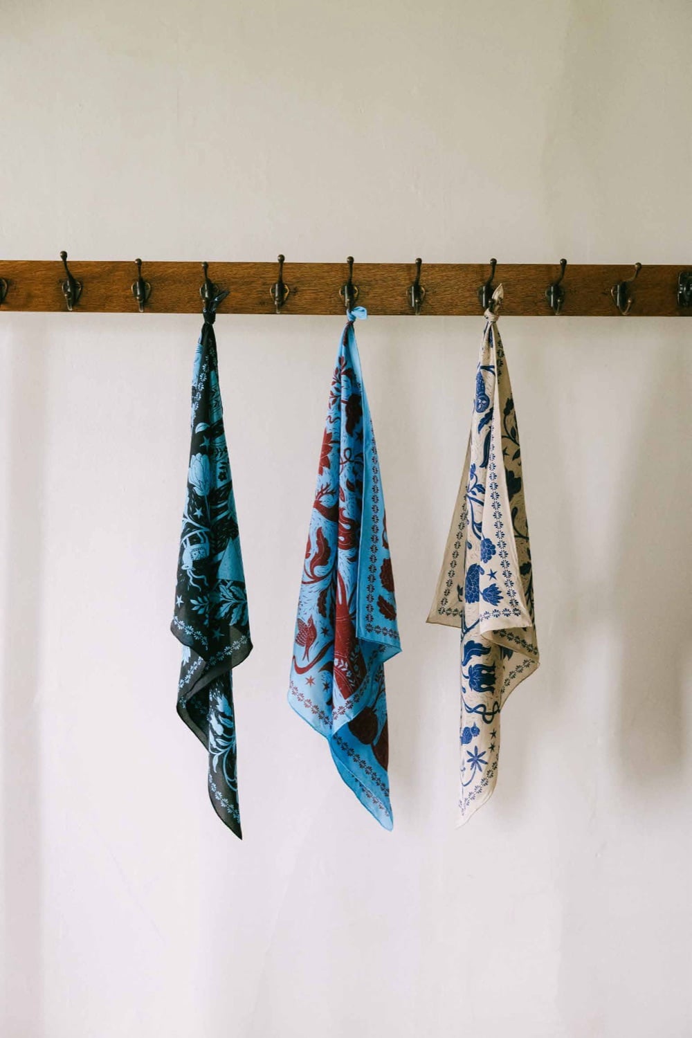 Three printed scarves from the America 250 collection on a rack